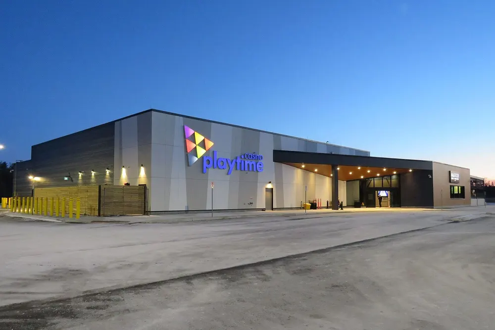 Playtime Casino Wasaga Beach at dusk: a low grey building with a long lit entrance canopy